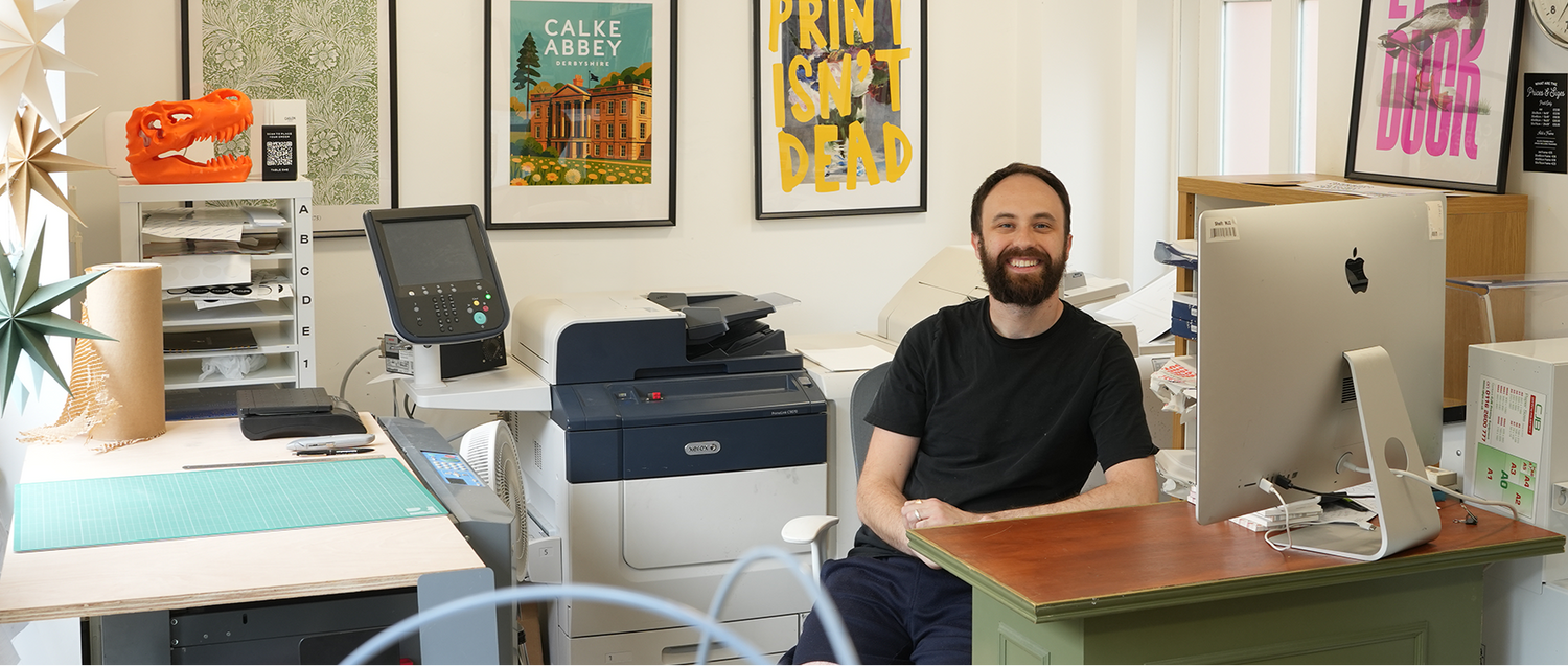 Rob sitting at a desk in the print shop